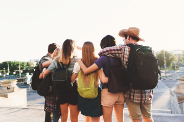 Traveling, sightseeing, vacation, holidays, adventure, friendship, togetherness Happy young people hugging looking at city view