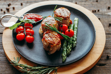 Restaurant food. Grilled pork dish with fresh vegetables. Medallions with herbs and spices.