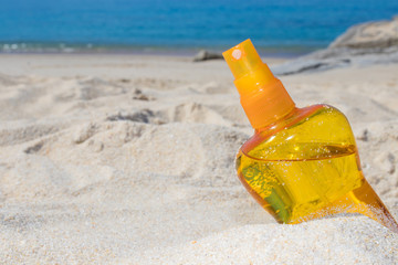 sunscreen or suntan lotion in the sand of the beach