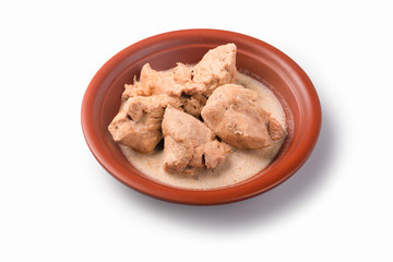 Fried pork large pieces, slices of pork in white sauce in a ceramic plate, isolated on white background