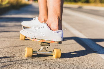 Close up of young woman's legs skateboarding