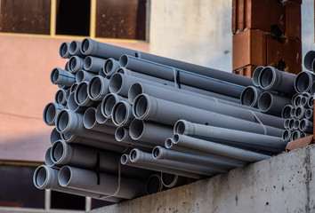 Plastic pipes are in a pile. lot of plastic sewer pipes.