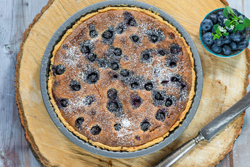 Blueberry and almond tart dusted with icing sugar - overhead view