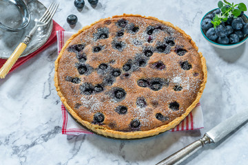 Blueberry and almond tart dusted with icing sugar