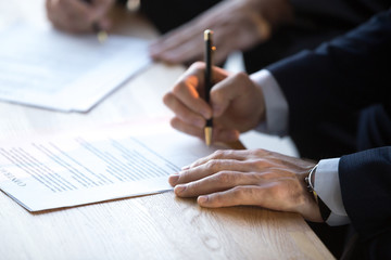 Close up of businessmen sign business contract after briefing