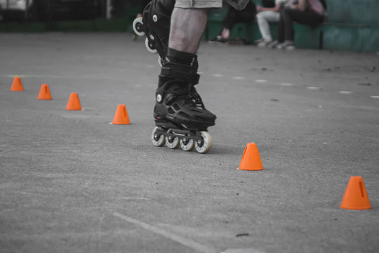 man skates on asphalt and goes round cones