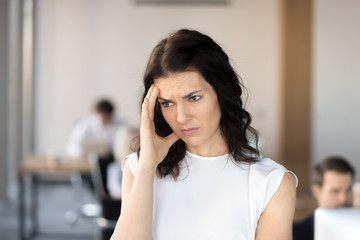 Exhausted female employee feel bad having headache at workplace