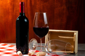 Bottle of red wine in wine cellar for tasting. Red wood background. Wine tradition and culture concept.