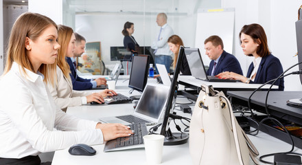 Fototapeta premium Young businesswoman concentrated on work with laptop in coworking space