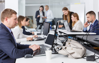 Focused nice successful man working with laptop