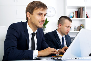 Business man sitting with laptop on desk