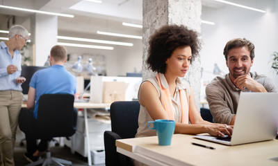 Team of colleagues brainstorming together while working in modern office