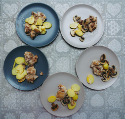 plates of pork with mushroom sauce and potatoes on the table with a gray tablecloth