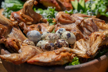 Traditional georgian food grilled chicken Tabaca with Quail eggs and fresh vegetables.
