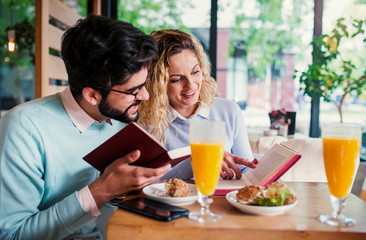 Couple of students sitting in a cafe, having breakfast. Love, dating, food, lifestyle concept