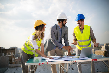 Architects, business manager and engineer meeting project at building site