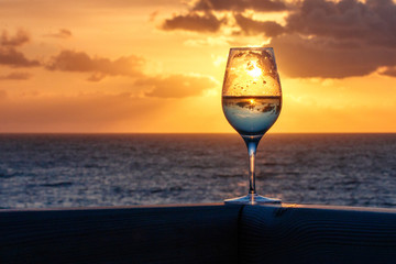 Weinglas vor dem Sonnenuntergang am Meer