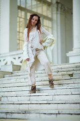 dreadlocks fashionable girl dressed in white posing on old palace background