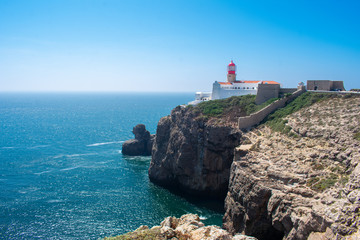 Fototapeta na wymiar Lighthouse on cliff in Sagres, Algarve. West Coast of Atlantic Ocean in Portugal