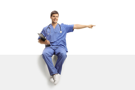 Doctor In A Blue Uniform Sitting On A White Panel And Pointing To The Side