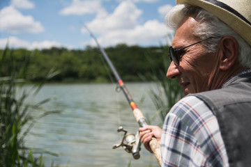 Senior man fishing by a lake