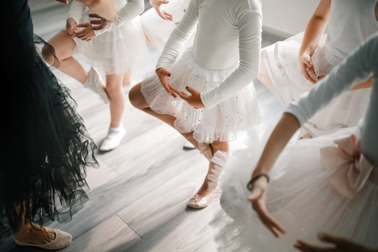 Ballet teacher and group of children ballerinas exercising in ballet studio