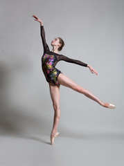 Fototapeta na wymiar Beautiful ballerina in pointe shoes and colorful clothes posing. 