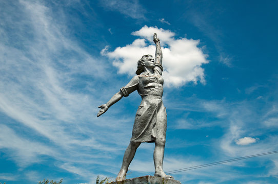 Proud woman historical monument on blue sky with white clouds background. Social realism sculpture in Odessa countryside of Ukraine. Monumental Sculptures of Social-Realism. Soviet woman statue.
