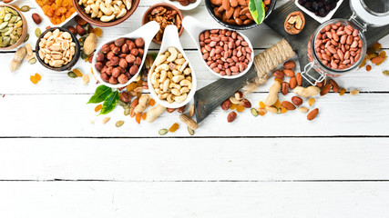 Assorted nuts on a white wooden background. Top view. Free space for your text.