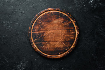 Old Wooden kitchen board on a black background. Top view. Free space for your text.