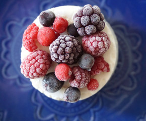 Frozen forest fruit, raspberries, blueberries, blackberries and currant on the top of the cheesecake, top view