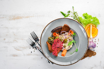 Herring tartar in a plate. Rustic style. Top view. Free space for your text.