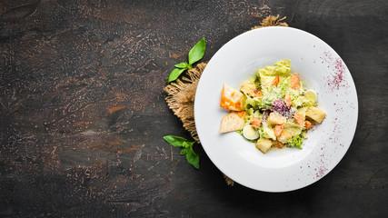 Vegetable Caesar salad with salmon. In the plate. Top view. Free space for your text. Rustic style.