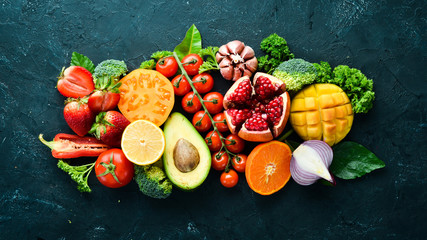 Fresh fruits, vegetables and berries. On a black background. Banner Top view. Free space for your...
