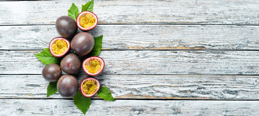 Passion fruits with a leaf on a white wooden background. Tropical Fruits. Top view. Free space for...