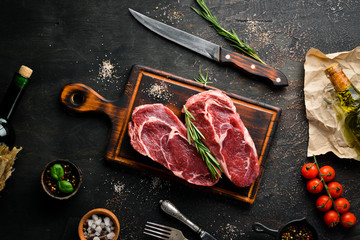 Fototapeta na wymiar Raw marbled meat Black Angus Steak Ribeye. At the aged table. Top view. Free space for your text.