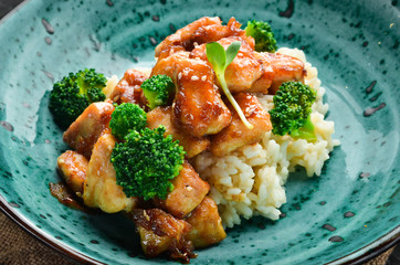 Rice with chicken fillet and broccoli. Thai cuisine. In the plate. Top view. Free space for your text. Rustic style.