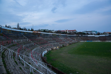 Abadoned Stadion Za  Luzankami is a currently inactive stadium in Brno, Czech Republic. Captured in spring sunset, sky and clouds was colored to blue dark colors. Photo from tribunes and inside middle