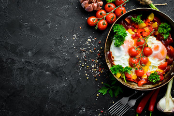 Shakshuka Eggs with tomatoes and vegetables in a frying pan. Breakfast. Top view. Free space for your text.
