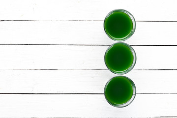 Healthy green wheat drink on a white background. Top view. Free space for your text.