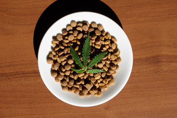 Treats for dogs and cats and green leaves of cannabis - CBD and medical marijuana for pets concept