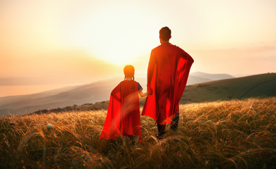 concept of father's day. dad and child daughter in hero superhero costume at sunset  . - obrazy, fototapety, plakaty