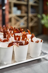 Snack to beer beef jerky in a paper cup - homemade dried jerky spiced meat, served in a street snack