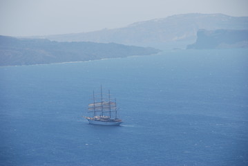 Naklejka premium Ship sailing off the coast of Santorini Island