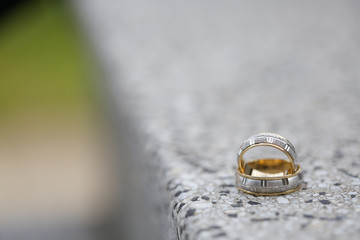 Golden wedding rings on a stone surface