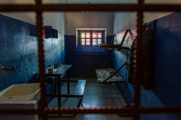 Empty prison cell in the worst prison in Russia. Two beds, a table, a washstand and a toilet are behind bars.