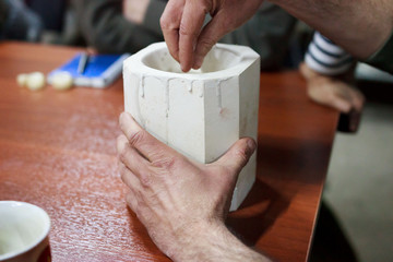 meeting potters. training courses for novice ceramists. the master potter with 15 years of experience shows a gypsum plaster mold for making many ceramic cups. reportage.
