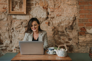 Smiling young woman using laptop in a cafe