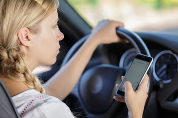 Fototapeta na wymiar woman using cellphone while driving