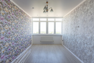 Empty room in the apartment after repair, with different wallpaper, with a large wide window